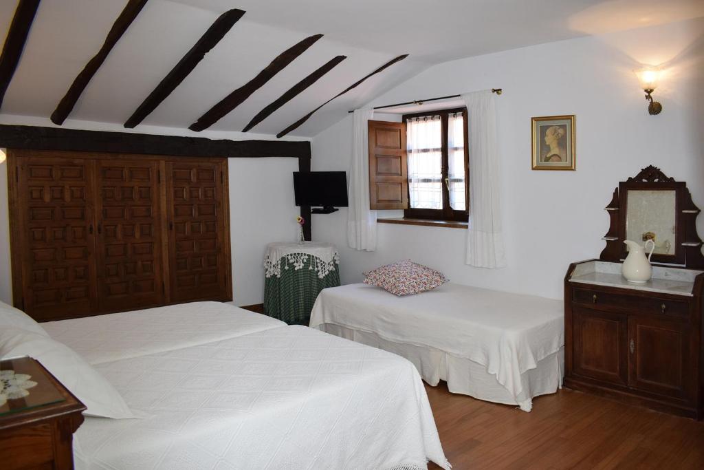 SelayaHabitaciones Casona De Linares的一间卧室设有两张白色的床和窗户