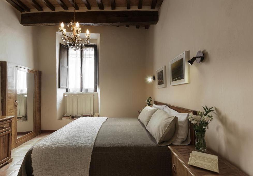 皮恩扎PienzaLettings "Casa Olivieri"的一间卧室配有一张床和一个吊灯