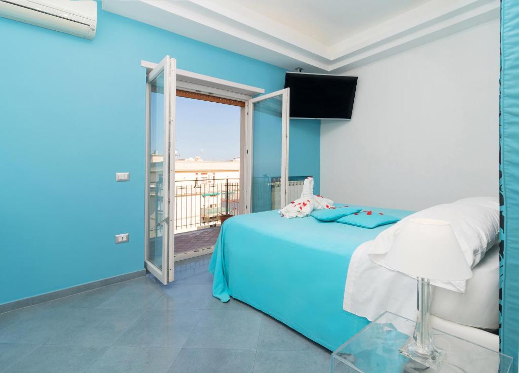 索伦托Guest House Emily Suites Sorrento的一间蓝色卧室,配有一张床和一个阳台
