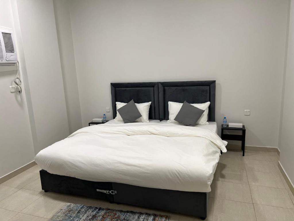 延布الشقق الذكية的卧室配有一张带白色床单和枕头的大床。