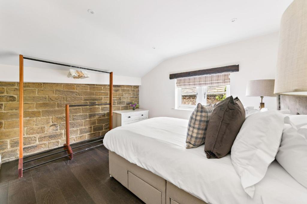 巴恩斯利Chantry House的一间卧室设有一张大床和砖墙