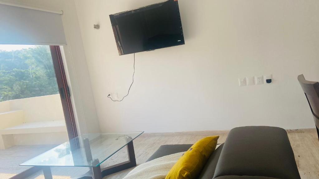 锡瓦塔塔内霍Luana suites- Suite Koya的客厅配有沙发和墙上的电视