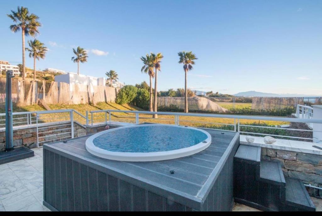 马拉加Casares del Mar Luxury Apartment的棕榈树甲板上的大型游泳池