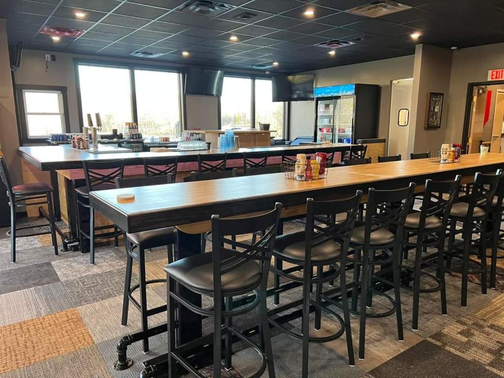 纳什维尔Salt Creek Golf Retreat的餐厅设有大型木制酒吧,配有黑色凳子