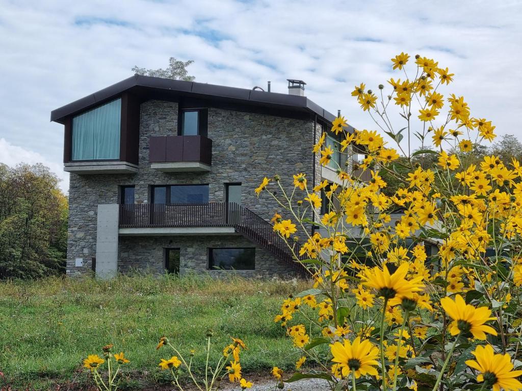 松德里奥Agriturismo B&B Caffè e Vino的一座花朵黄色的小山顶上的房子