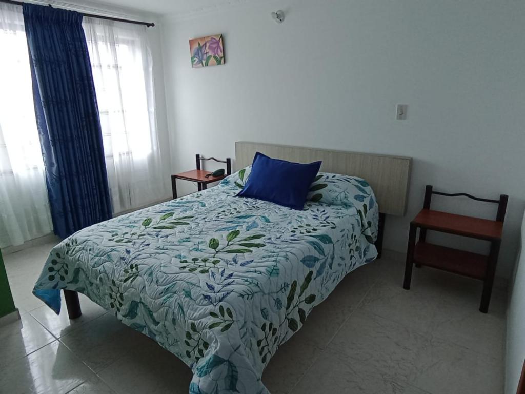 比亚维森西奥Diamante Blue Hotel的一间卧室配有一张带蓝色枕头和椅子的床