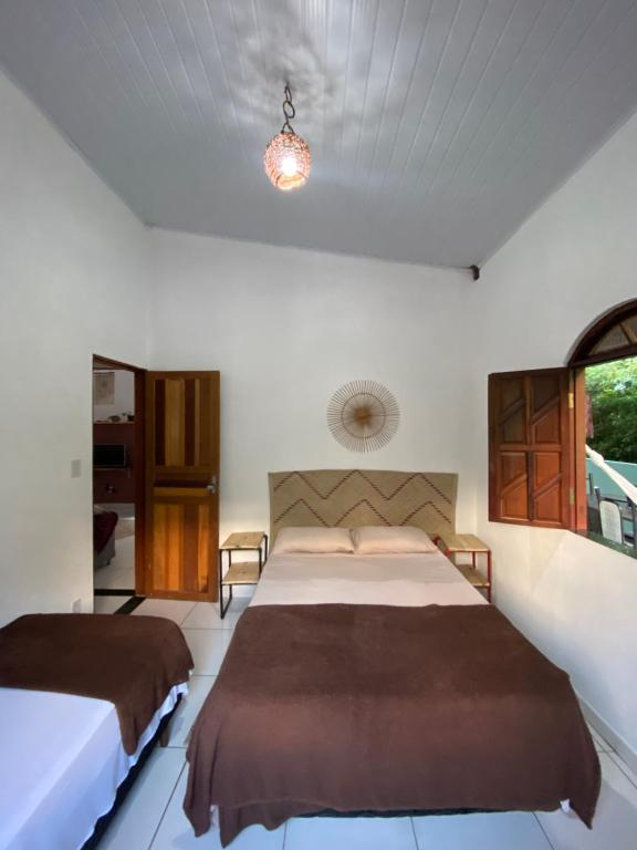 伦索伊斯Terra Hostel e Pousada的一间卧室设有两张床和窗户。