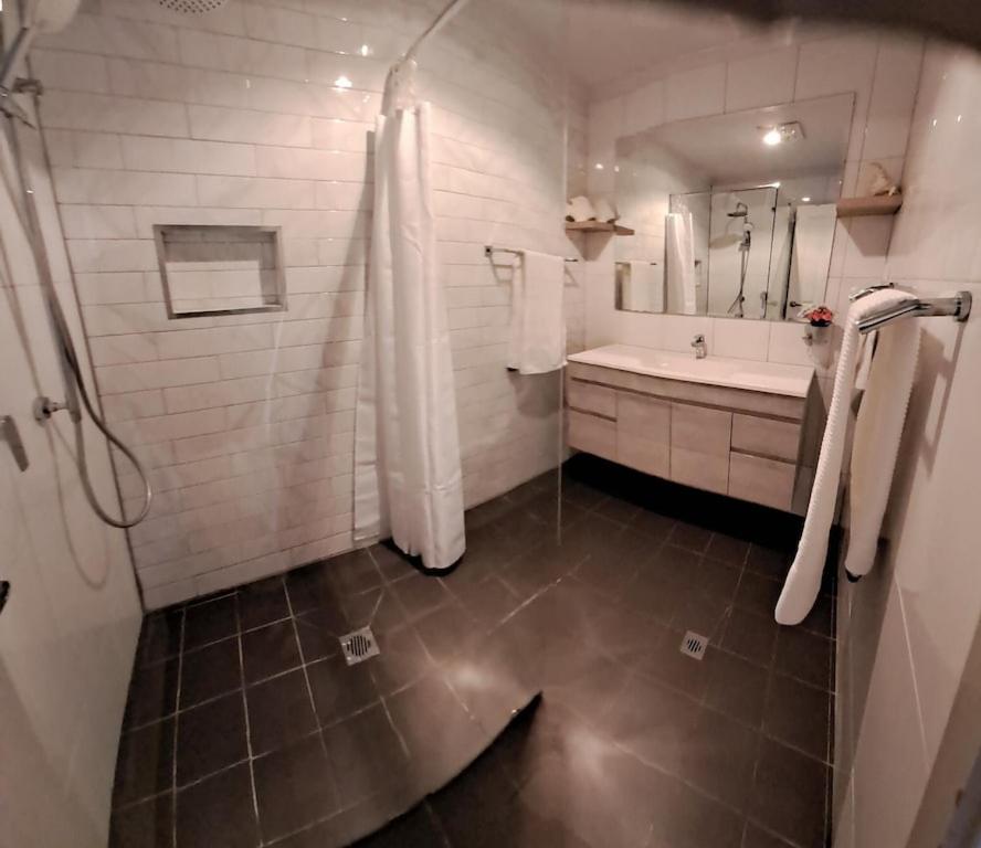 布罗肯希尔Cummins Cottage的带淋浴、盥洗盆和浴缸的浴室