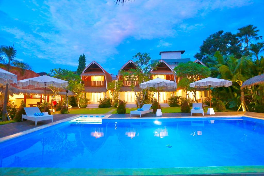 坎古37 Sunset Village Bali的夜间带游泳池的别墅