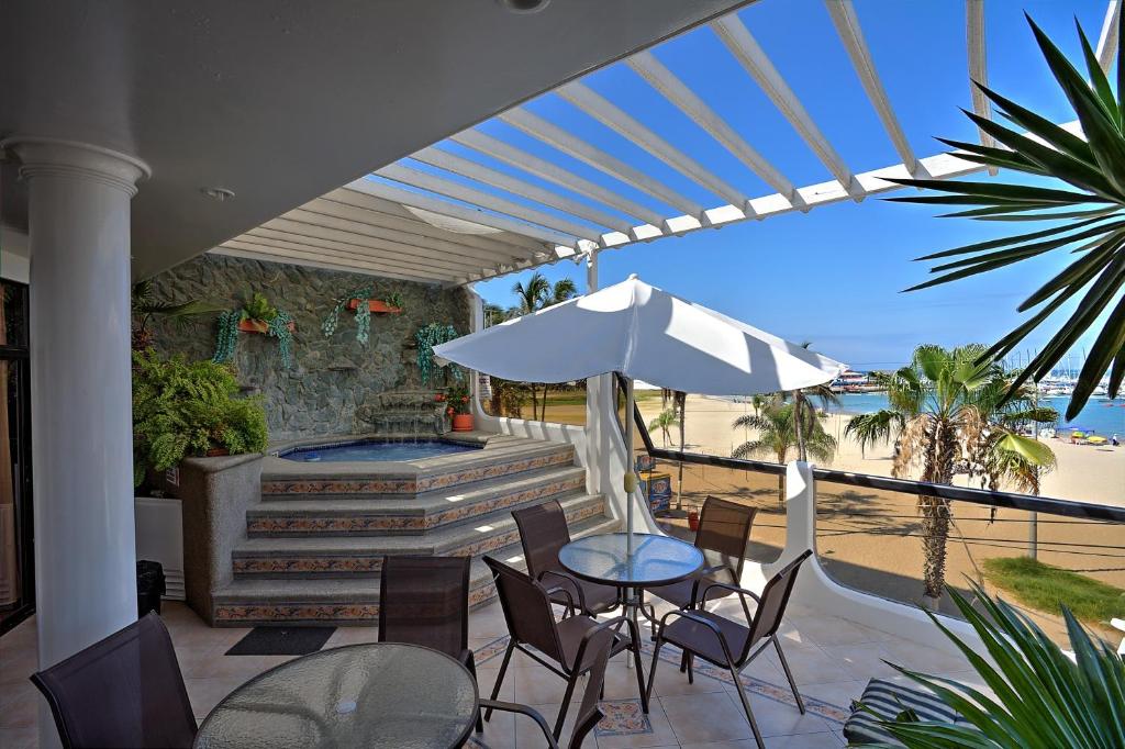 萨利纳斯萨利纳斯卡萨布兰卡酒店的庭院配有桌椅和遮阳伞。