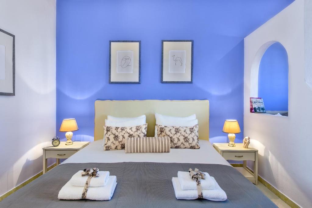 普拉塔尼亚斯艾格米亚假日公寓式酒店的蓝色卧室,配有带毛巾的床