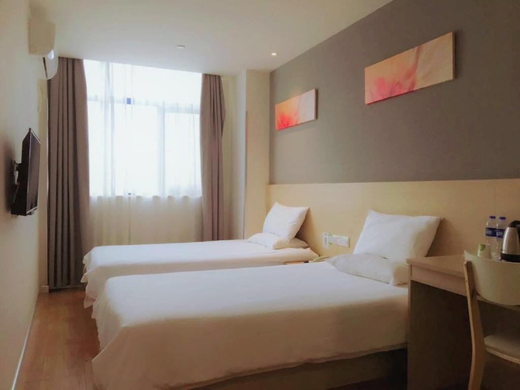 上海海友上海虹桥火车站酒店的酒店客房设有两张床和窗户。