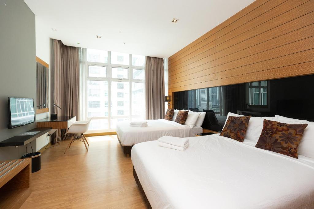 吉隆坡Dua Sentral by Cobnb的酒店客房设有两张床和电视。