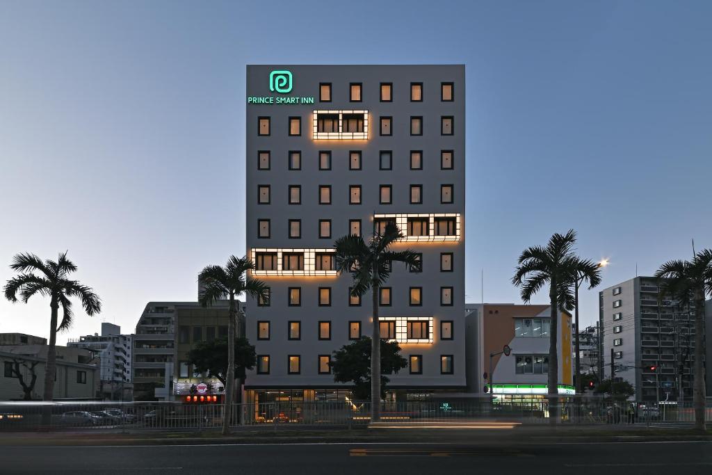 那霸Prince Smart Inn Naha的一座高大的建筑,在城市里种有棕榈树