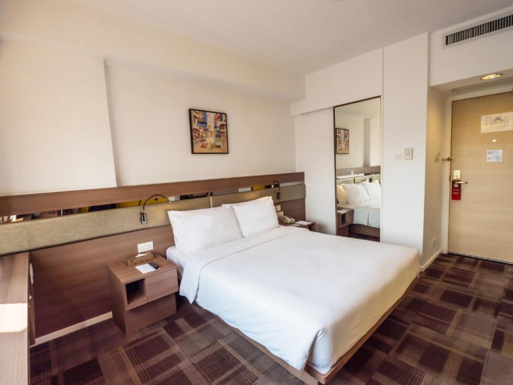 香港九龙彩鸿酒店的酒店客房,配有床和镜子