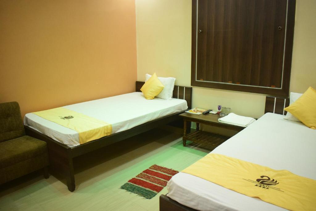 加雅Hotel Shakuntla Palace的酒店客房,配有两张床和椅子