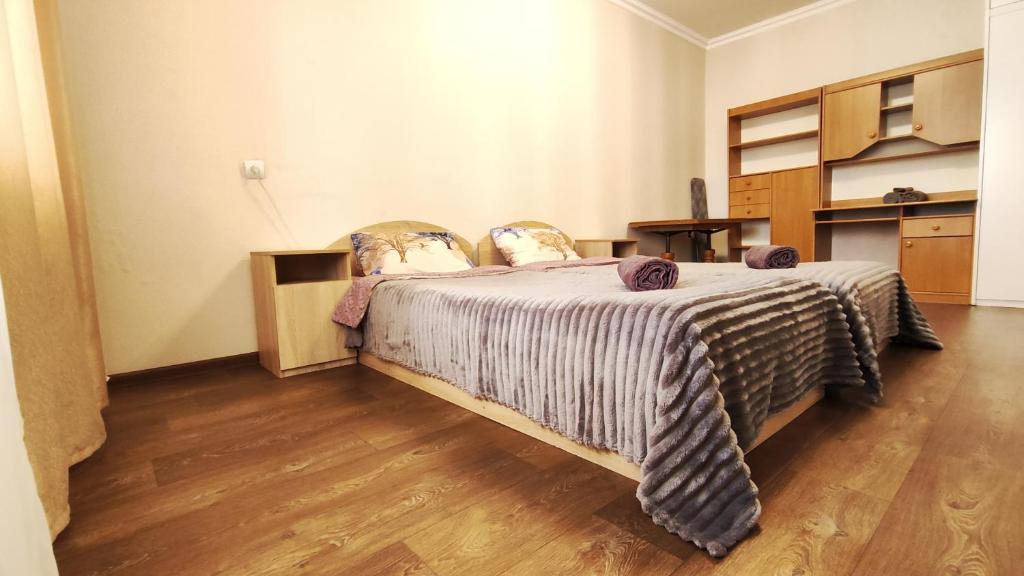 白采尔科维Водопійна 19 CityRooms的一间卧室配有一张床,铺有木地板