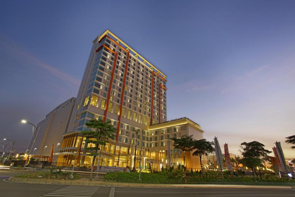 贝克西贝克西哈里斯会议酒店（HARRIS Hotel & Conventions Bekasi）的一座高大的建筑,城市里灯火通明