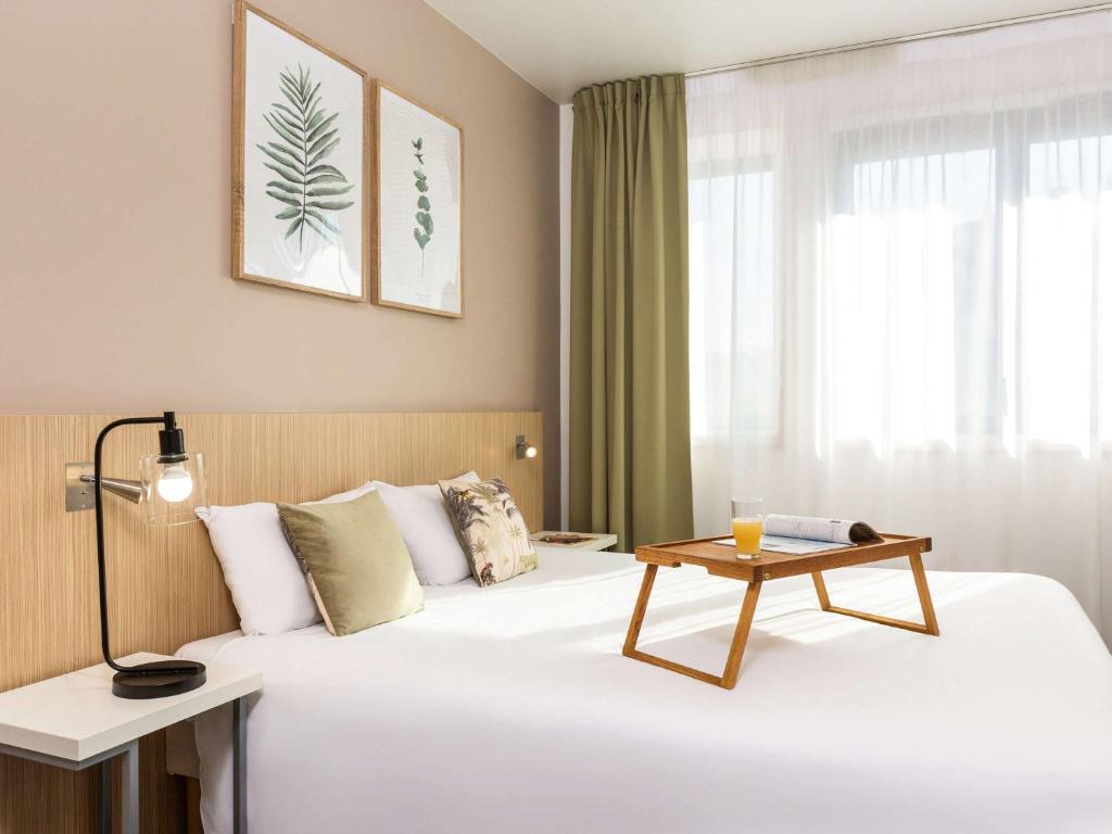 巴黎巴黎勒伊阿德吉奥阿克瑟斯公寓式酒店的酒店客房,配有一张桌子和一张床铺