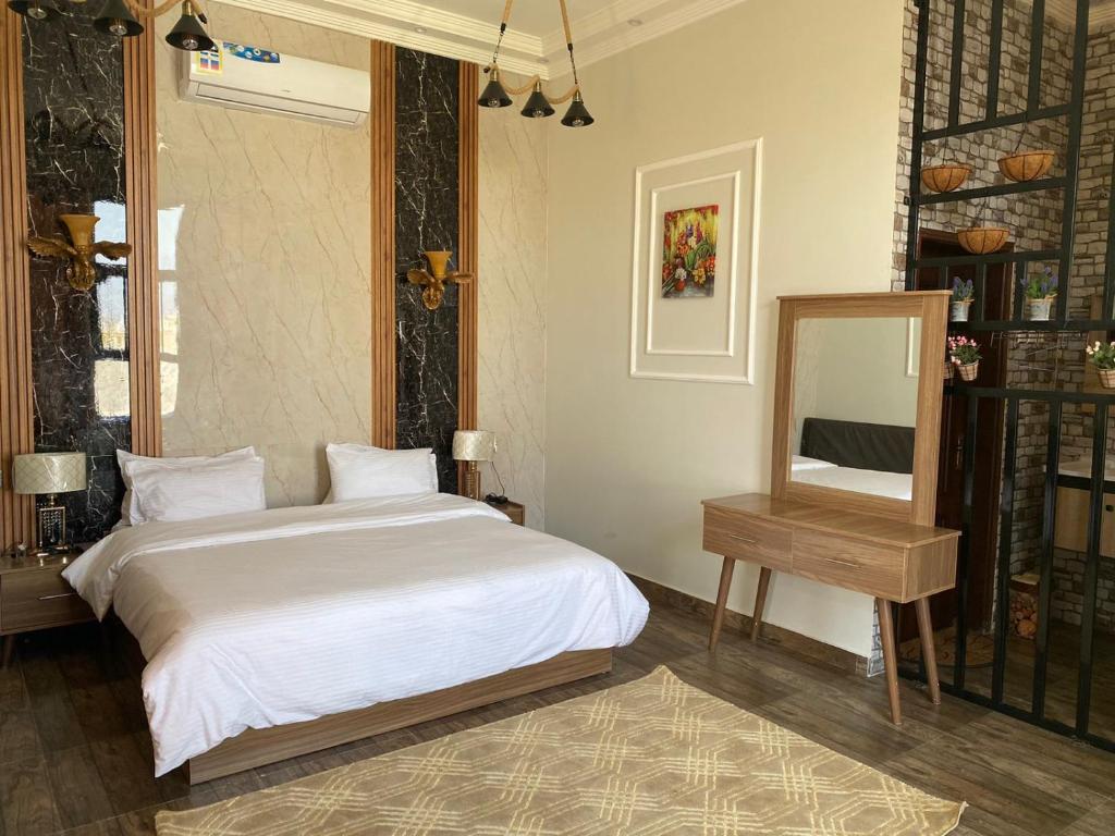 塞拉莱Alnoor Mirbat的一间卧室配有一张床、镜子和一张桌子