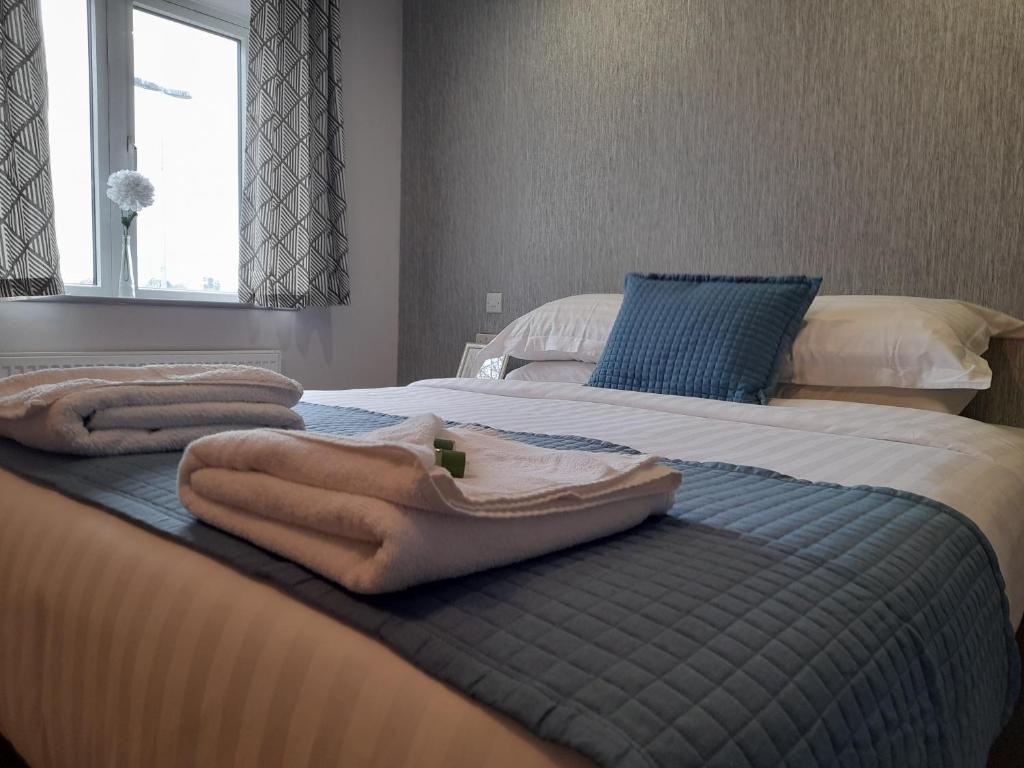 CranfordApartments Heathrow - Hounslow的一间卧室配有两张带毛巾的床