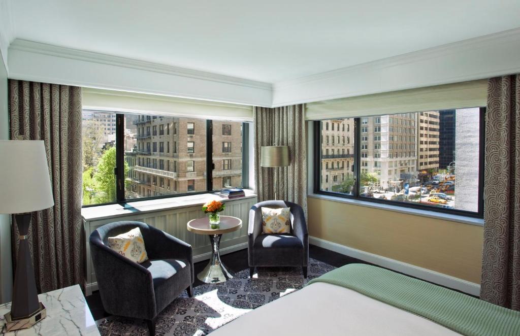 纽约纽约丽晶洛斯酒店的酒店客房设有一张床、两把椅子和一扇窗户。