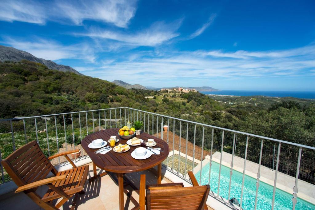 PátimaVilla Cretan View with Heated Swimming Pool的海景阳台上的桌子