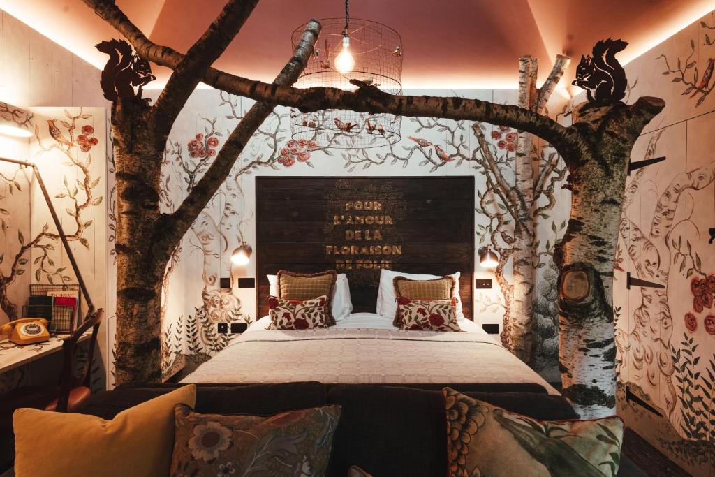 TicehurstThe Bell in Ticehurst的卧室配有一张墙上树木环绕的床