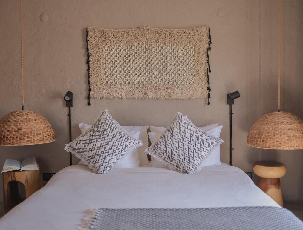 阿拉恰特GAIA ALAÇATI的卧室配有带两盏灯的白色床