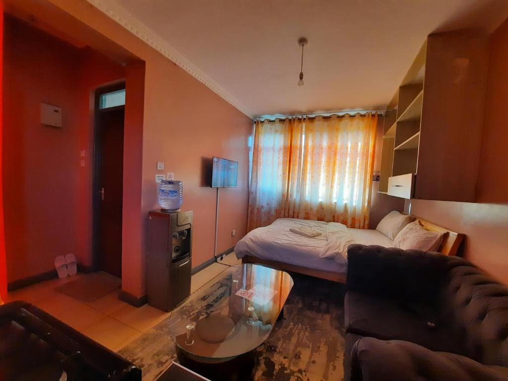 KikuyuPine Residency w Secure Parking, Wifi, Netflix & Rooftop Views的小房间设有床和沙发