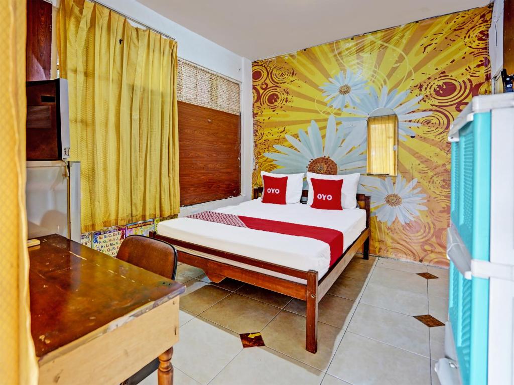泗水OYO 92270 Grand Village Syariah的一间卧室配有一张带红色枕头的床