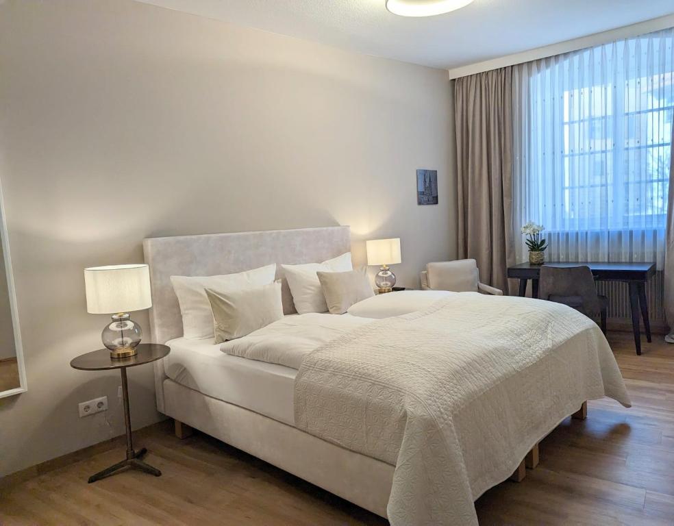 班贝格Hotel Martin am Dom的卧室配有一张白色大床和一把椅子