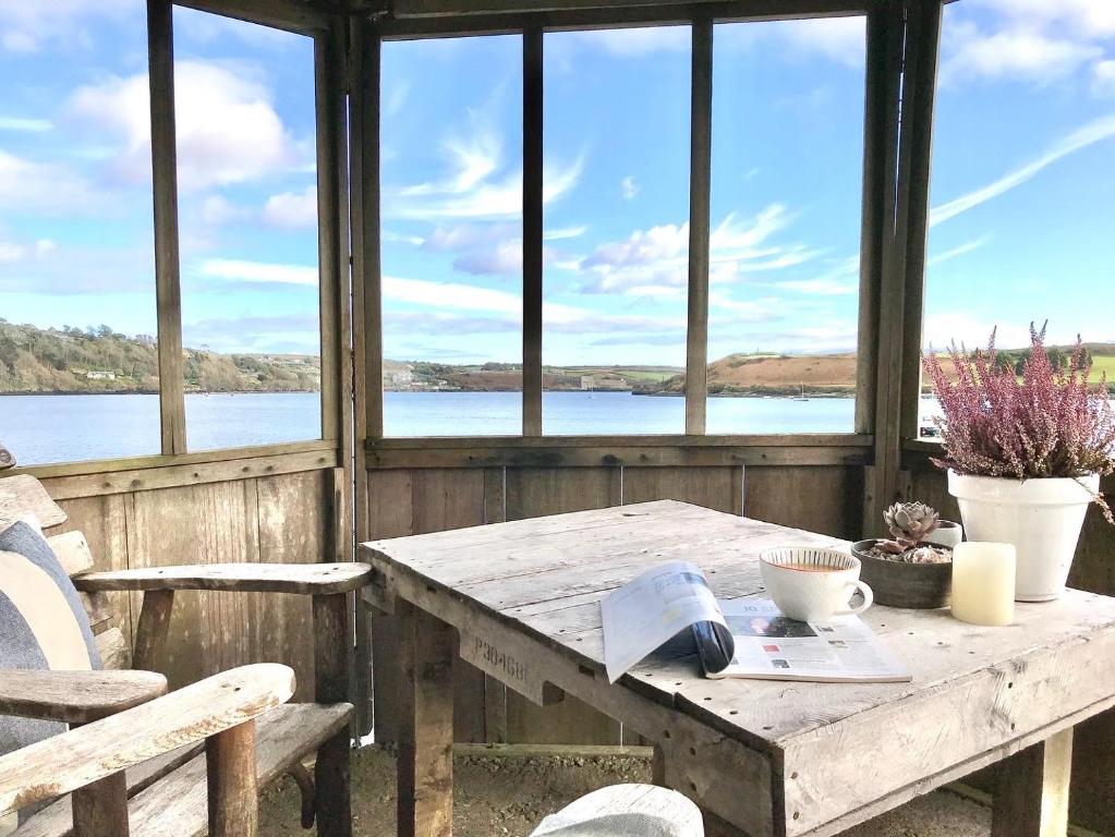 金塞尔Coastal Chic waterfront studio的一张木桌和椅子,享有湖景