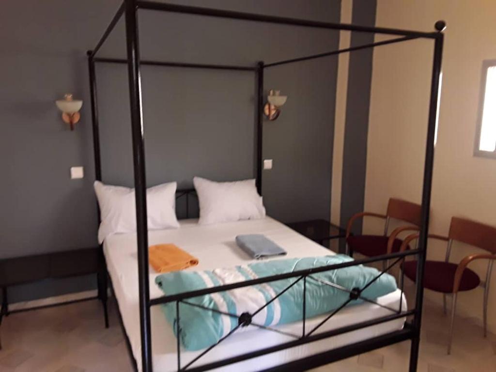 圣路易斯HÔTEL ETOILE DU SUD的一间卧室配有一张黑色金属框架床