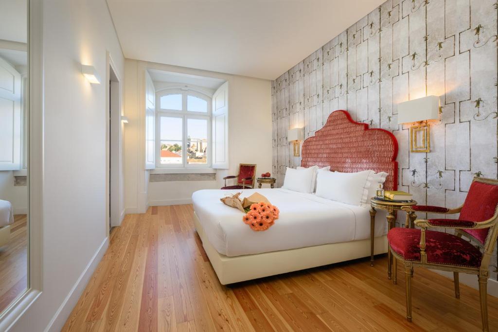里斯本Residentas Arco do Bandeira的一间卧室配有一张白色大床和红色床头板