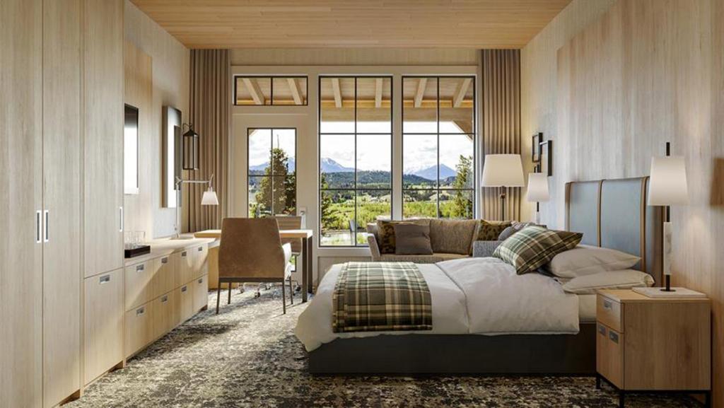 因弗米尔Headwaters Lodge at Eagle Ranch Resort的一间卧室配有一张床、一张桌子和一张椅子
