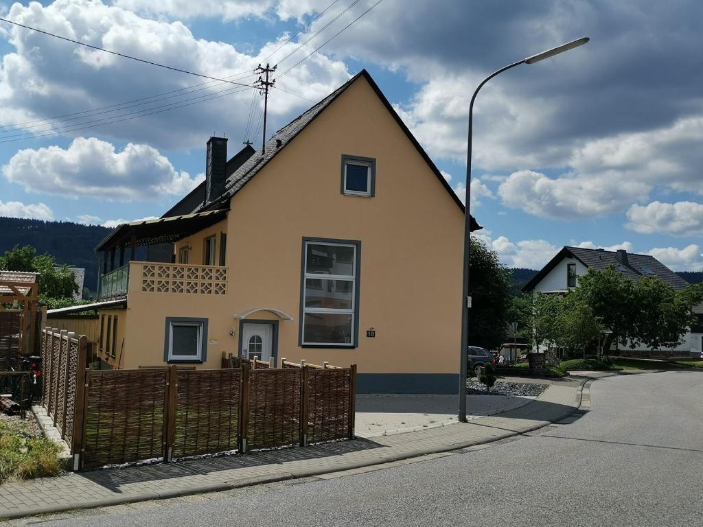 AllenbachFerienhaus Clarissa的黄色的房子,有栅栏和街灯