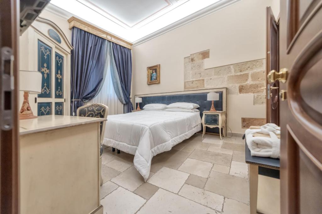 切利诺圣马尔科Kelina Charme Hotel by Cantine Due Palme的一间卧室配有一张特大号床和蓝色窗帘