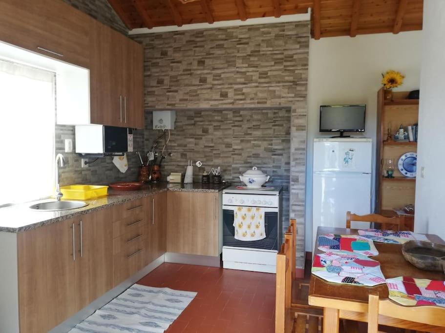 Quinta do Girassol - AL的厨房配有炉灶、冰箱和桌子
