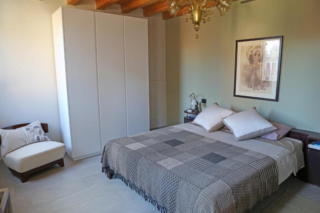 穆拉诺Shuttered Dreams Murano Venice的一间卧室配有一张大床和一个吊灯。