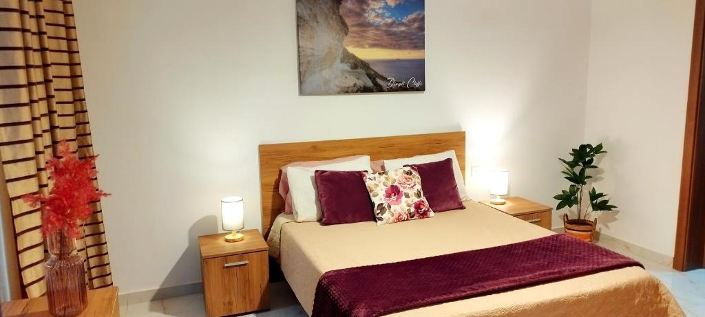 莫斯塔Stylish apartment in central Malta的一间卧室配有一张带2个床头柜和2盏灯的床。