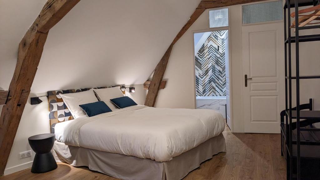 博讷Le 14 Faubourg的一间卧室设有一张大床和一个窗户。
