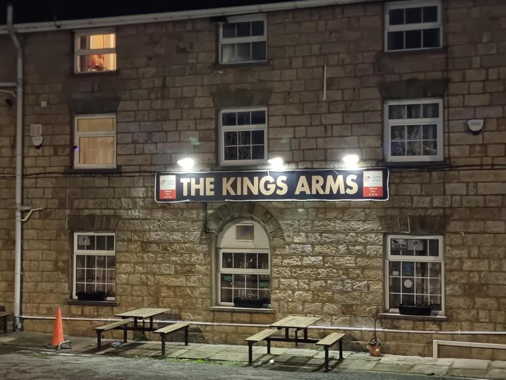 埃布韦尔Kings Arms Hotel Ebbw Vale的前面有长椅的砖砌建筑