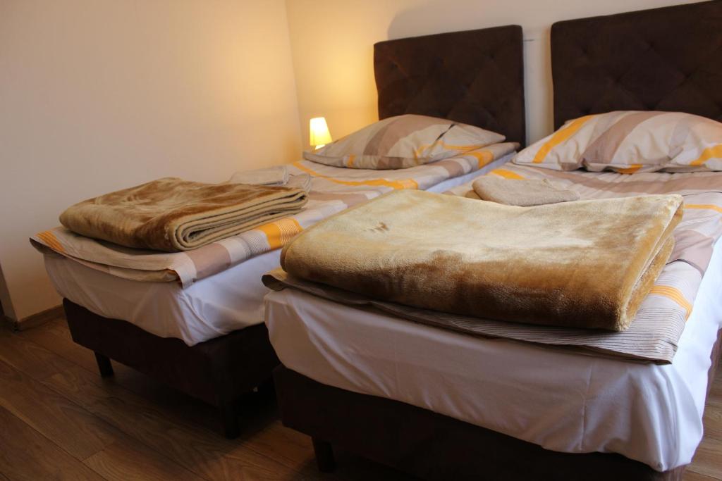 托伦Dom Pielgrzyma的客房内的两张床和毯子