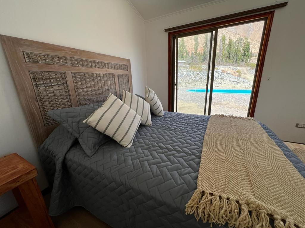 Monte GrandeRefugio Alma de Montaña, piscina privada的卧室配有带枕头的床铺和窗户。