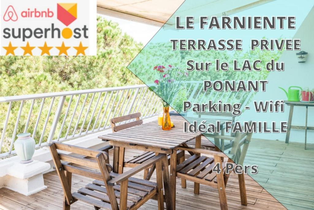 拉格朗德默特LE FARNIENTE - BELLE TERRASSE Wifi Parking à 5 Min des PLAGES - TOP PROS SERVICESConciergerie La Grande Motte的甲板上配有一张木桌子和椅子,配有遮阳伞