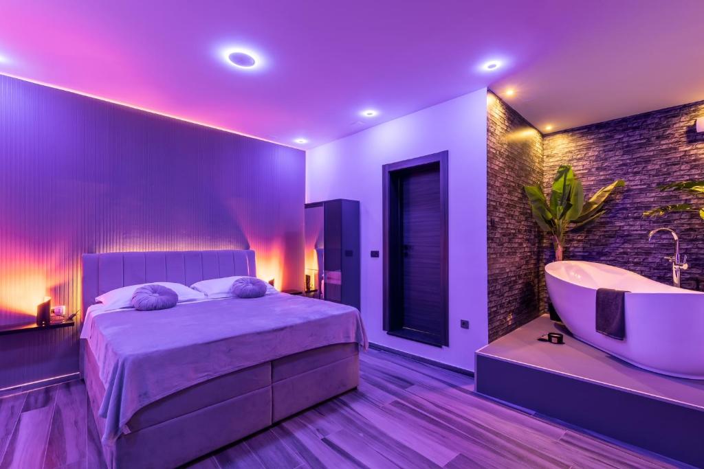索林Luxury room Ekstaza的一间卧室配有一张床、一个浴缸和一个水槽