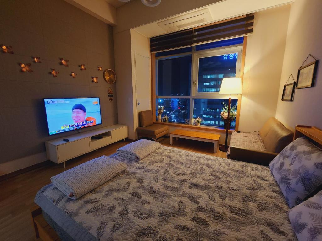 大邱Y stay的一间卧室配有一张床和一台平面电视