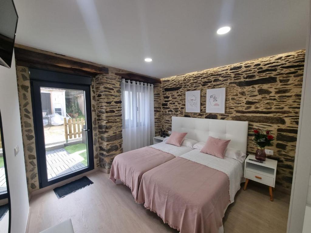 阿尔苏阿A CASIÑA DE ISABEL的一间卧室设有一张床和砖墙