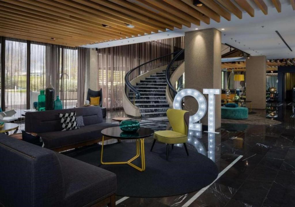 堪培拉堪培拉QT酒店的带沙发和螺旋楼梯的客厅